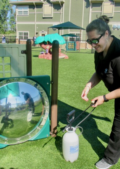 Staff member Janene Birman disinfecting a playground after recess.