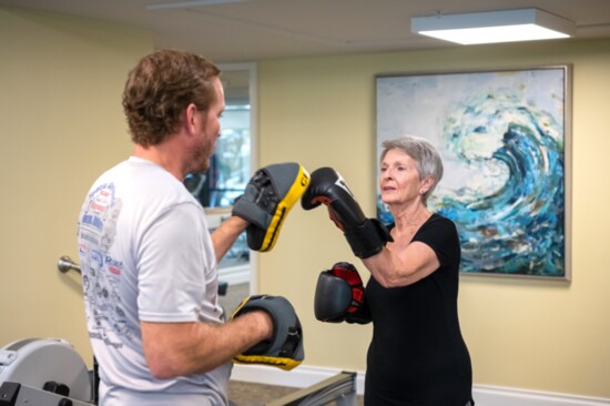 Coach Lee Anderson leads Pat Mousley through boxing combinations.